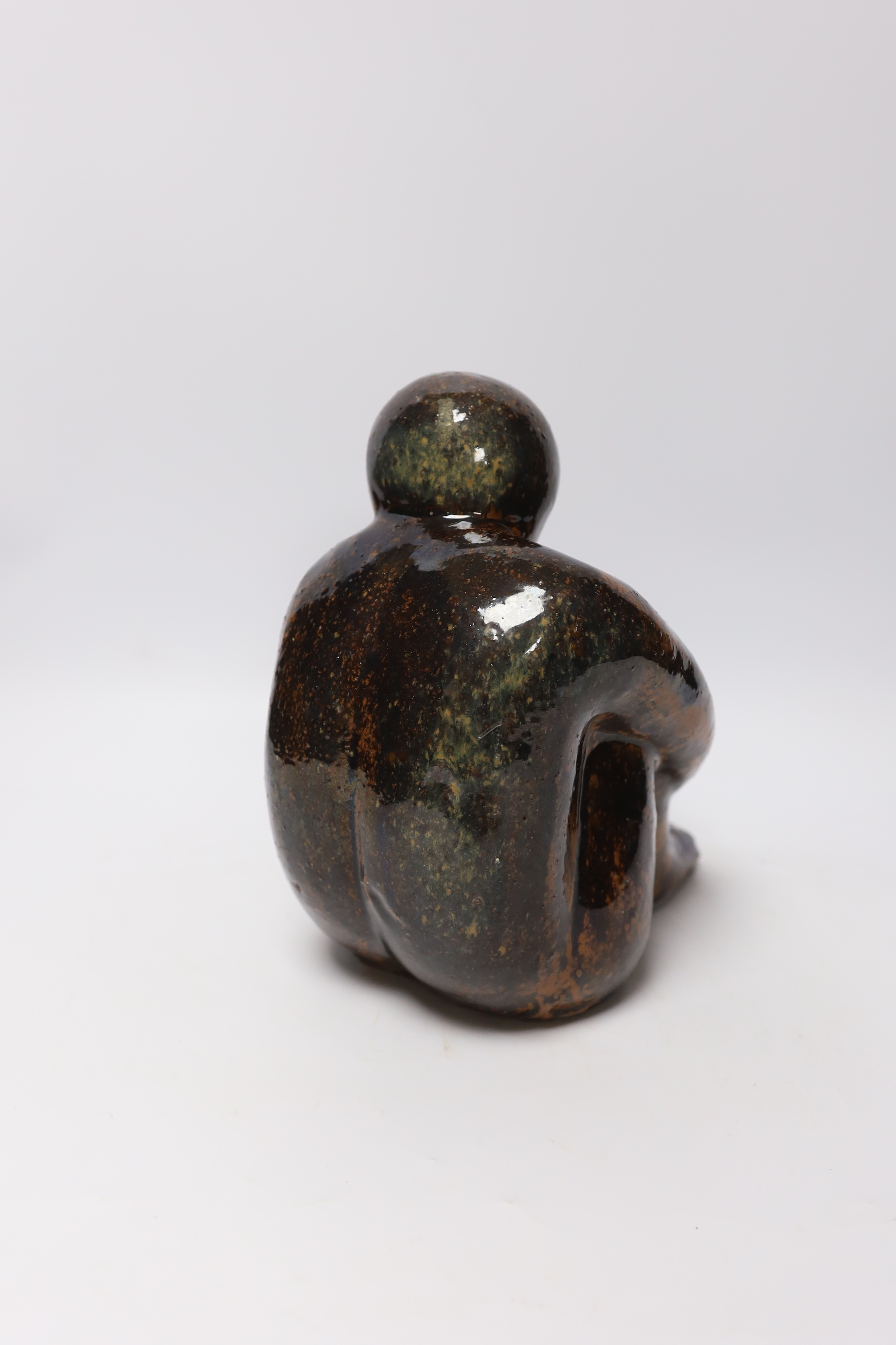 A 20th century tenmoko glazed pottery figure of a seated figure, 22cm